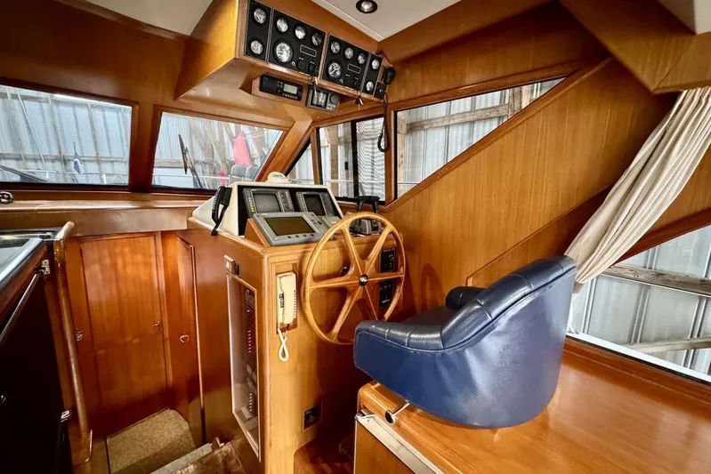  Yacht Photos Pics 1998 Ocean Alexander 420 helm with wooden dashboard, steering wheel, and blue captain's chair.