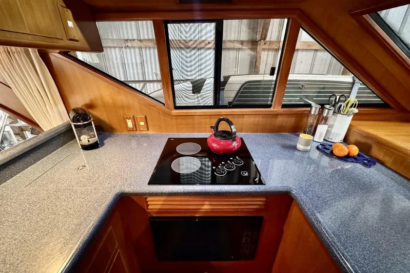  Yacht Photos Pics 1998 Ocean Alexander 420 yacht kitchen with stove, red kettle, and countertop accessories.