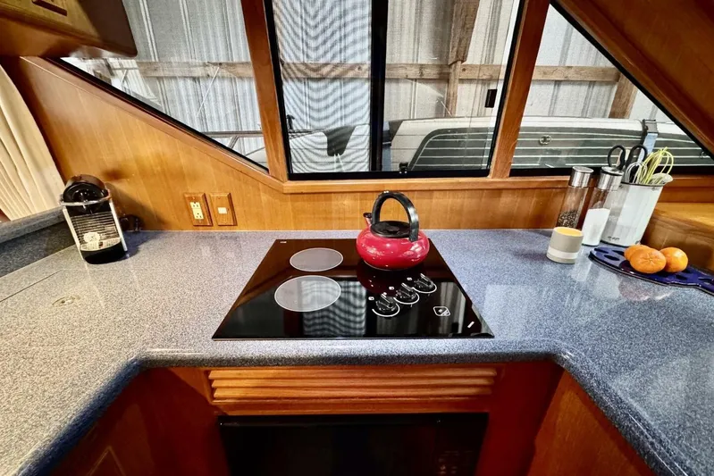  Yacht Photos Pics 1998 Ocean Alexander 420 yacht kitchen with stove, red kettle, and countertop accessories.