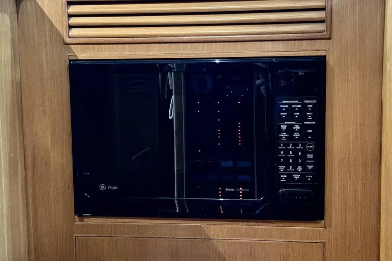  Yacht Photos Pics Built-in microwave in 1998 Ocean Alexander 420 yacht kitchen, featuring wood paneling.