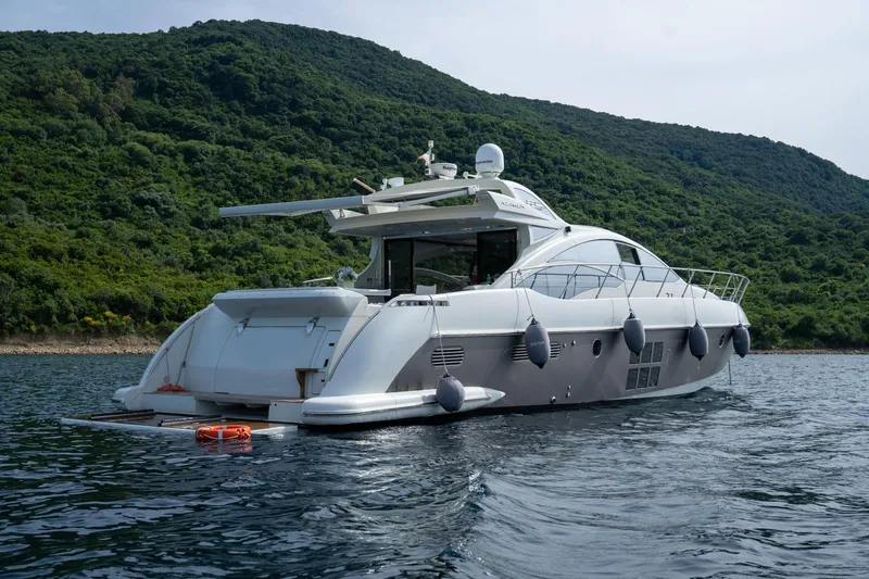Barba III Yacht Photos Pics Luxury 2013 Azimut AZ 62S ITALIA yacht cruising near lush green coastline.