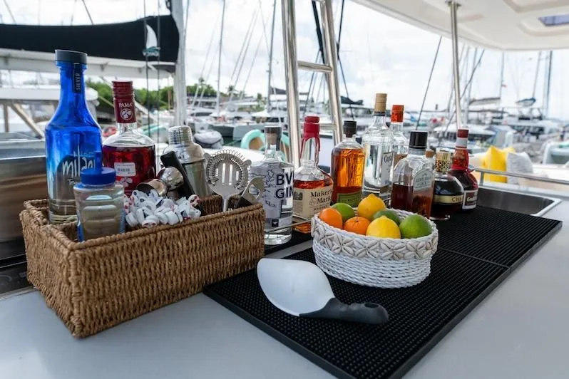 Ruby One Yacht Photos Pics Bar setup on a 2020 Leopard 58 yacht with assorted drinks and fruits.