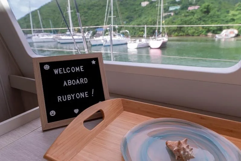 Ruby One Yacht Photos Pics Welcome aboard sign on Leopard 58 yacht with scenic marina view.