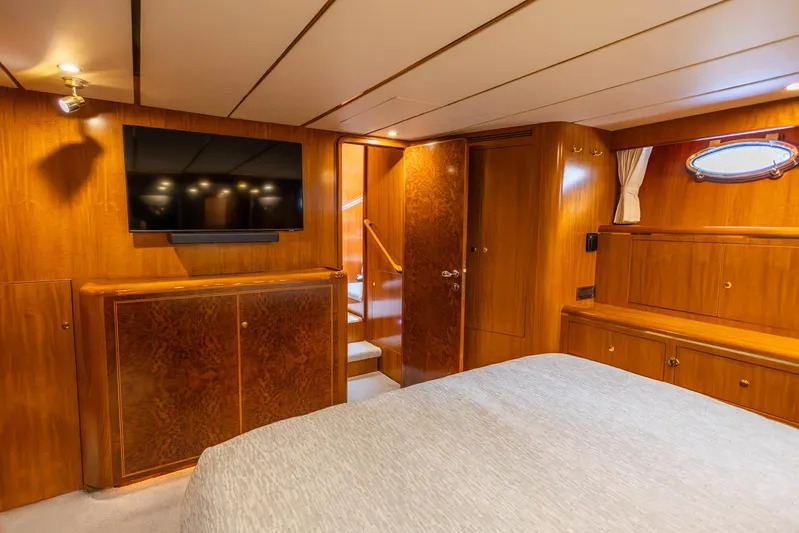 Bluewater Yacht Photos Pics Luxurious 2005 Ocean Alexander yacht bedroom with wood paneling and mounted TV.