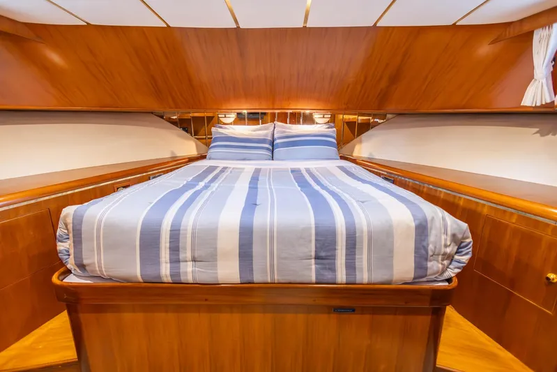 Bluewater Yacht Photos Pics Luxurious 2005 Ocean Alexander yacht bedroom with striped bedding and elegant wood finish.
