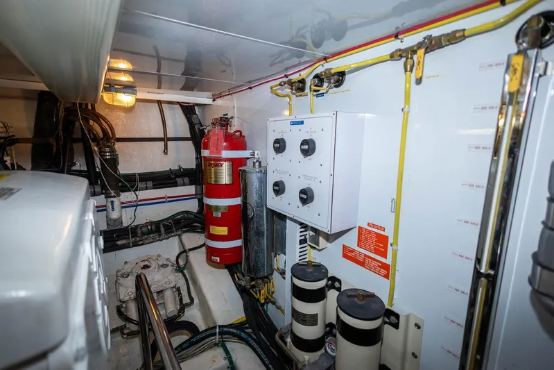 Bluewater Yacht Photos Pics Engine room of 2005 Ocean Alexander Raised Pilothouse Flybridge Sedan with control panel and fire extinguisher.