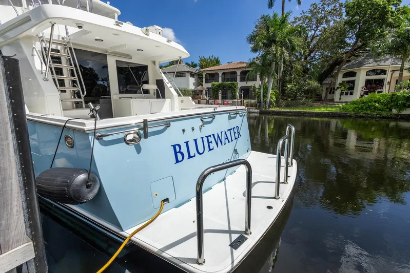 Bluewater Yacht Photos Pics 2005 Ocean Alexander Raised Pilothouse Flybridge Sedan docked by waterfront homes.