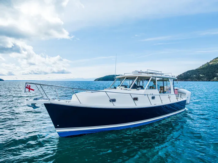 Misty Yacht Photos Pics 2007 Mainship Pilot 34 boat cruising on clear blue water under a partly cloudy sky.