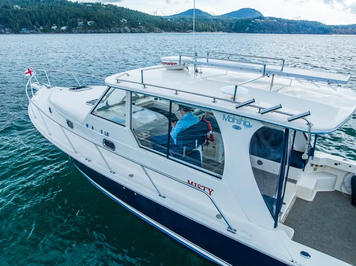 Misty Yacht Photos Pics 2007 Mainship Pilot 34 cruising on scenic lake with forested hills in the background.