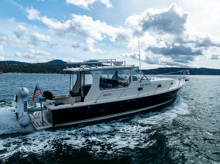 Misty Yacht Photos Pics 2007 Mainship Pilot 34 cruising on open water under a cloudy sky.