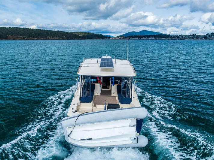 Misty Yacht Photos Pics 2007 Mainship Pilot 34 cruising on a scenic lake with mountains in the background.