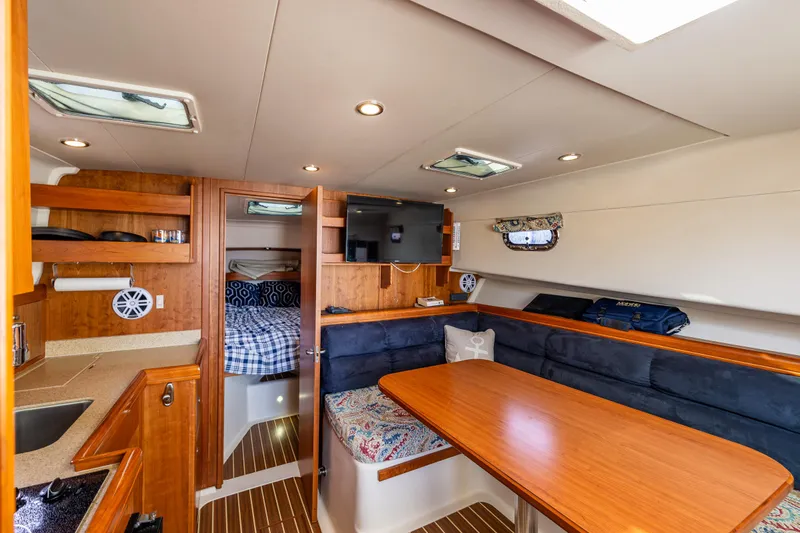 Misty Yacht Photos Pics Luxurious interior of 2007 Mainship Pilot 34 yacht with dining area and cozy cabin.