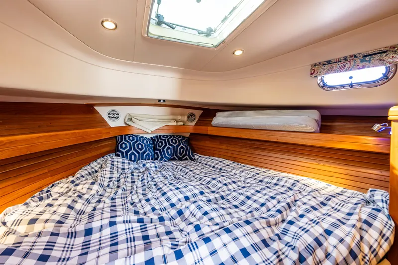 Misty Yacht Photos Pics Cozy cabin interior of 2007 Mainship Pilot 34 with plaid bedding and wooden accents.
