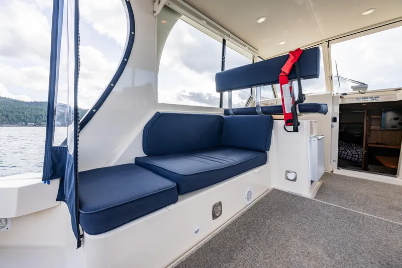 Misty Yacht Photos Pics 2007 Mainship Pilot 34 interior with blue seating and life jacket, showcasing comfort and style.