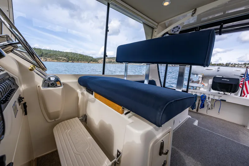 Misty Yacht Photos Pics 2007 Mainship Pilot 34 interior with blue seating, overlooking scenic water view.