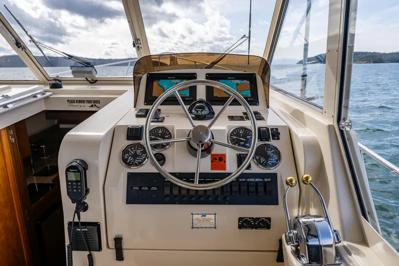 Misty Yacht Photos Pics 2007 Mainship Pilot 34 helm with steering wheel, gauges, and navigation equipment on open water.