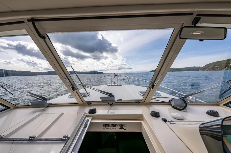 Misty Yacht Photos Pics 2007 Mainship Pilot 34 boat interior view, navigating through scenic waters under a cloudy sky.