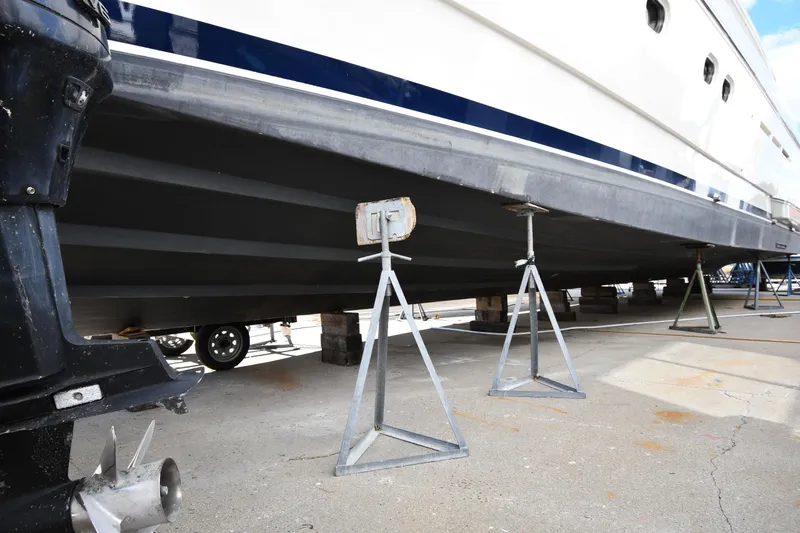 Surfin The Net Yacht Photos Pics 2001 Ferretti Yachts 72 on stands for maintenance, showcasing hull and propeller.