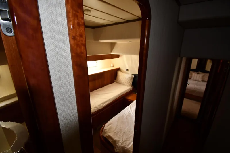 Surfin The Net Yacht Photos Pics Cozy cabin interior of 2001 Ferretti Yachts 72, featuring wooden finishes and comfortable bedding.