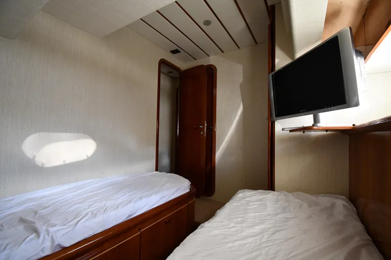 Surfin The Net Yacht Photos Pics Interior cabin of 2001 Ferretti Yachts 72 with twin beds and wall-mounted TV.