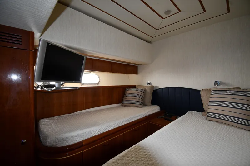 Surfin The Net Yacht Photos Pics Twin cabin interior of 2001 Ferretti Yachts 72 with TV and striped pillows.