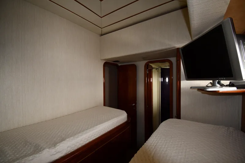 Surfin The Net Yacht Photos Pics Interior cabin of 2001 Ferretti Yachts 72 with twin beds and wall-mounted TV.