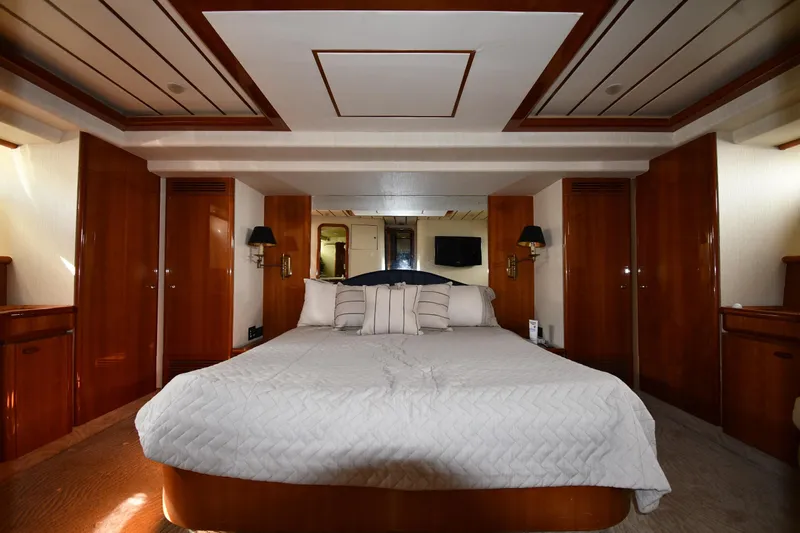 Surfin The Net Yacht Photos Pics Luxurious bedroom interior on 2001 Ferretti Yachts 72, featuring elegant wood paneling and cozy bedding.