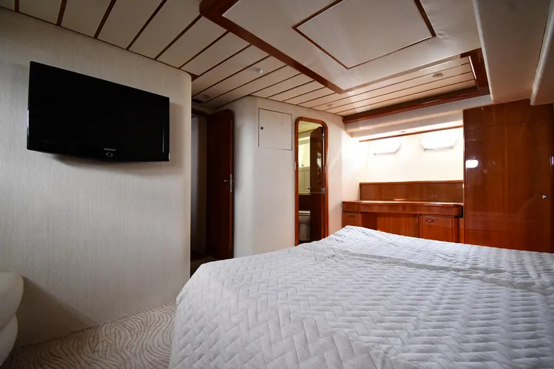 Surfin The Net Yacht Photos Pics Luxurious bedroom interior of 2001 Ferretti Yachts 72, featuring elegant wood finishes and modern amenities.