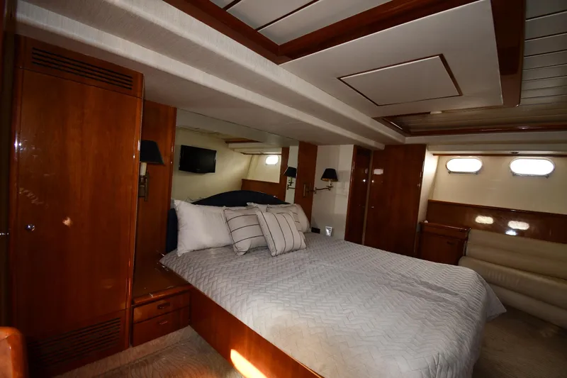 Surfin The Net Yacht Photos Pics Luxurious bedroom interior of 2001 Ferretti Yachts 72 with wood paneling and cozy bedding.