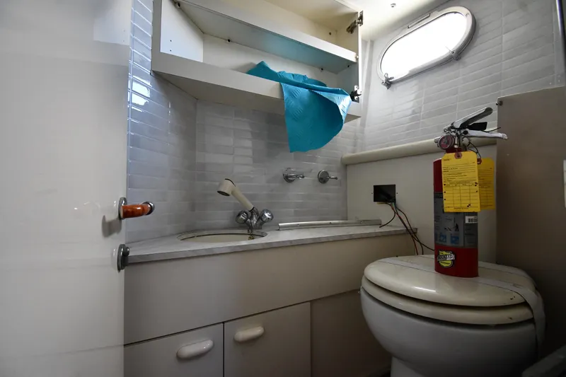 Surfin The Net Yacht Photos Pics Bathroom interior of 2001 Ferretti Yachts 72, featuring sink, toilet, and fire extinguisher.