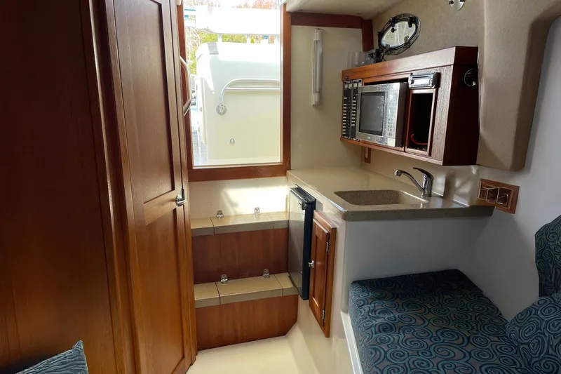 Low Bid Yacht Photos Pics Interior of 2007 Albemarle 280 Express Fisherman with kitchenette and seating area.