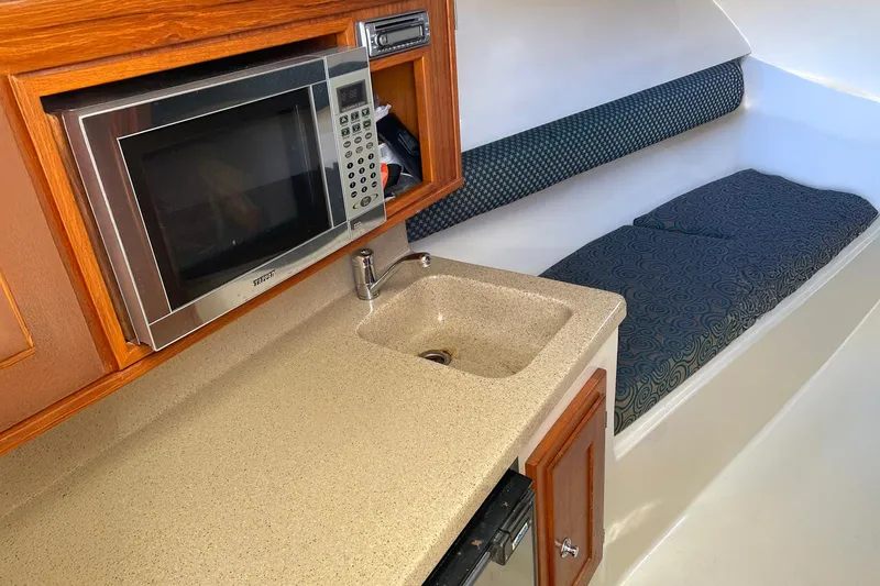 Low Bid Yacht Photos Pics 2007 Albemarle 280 Express Fisherman interior with kitchenette and seating area.