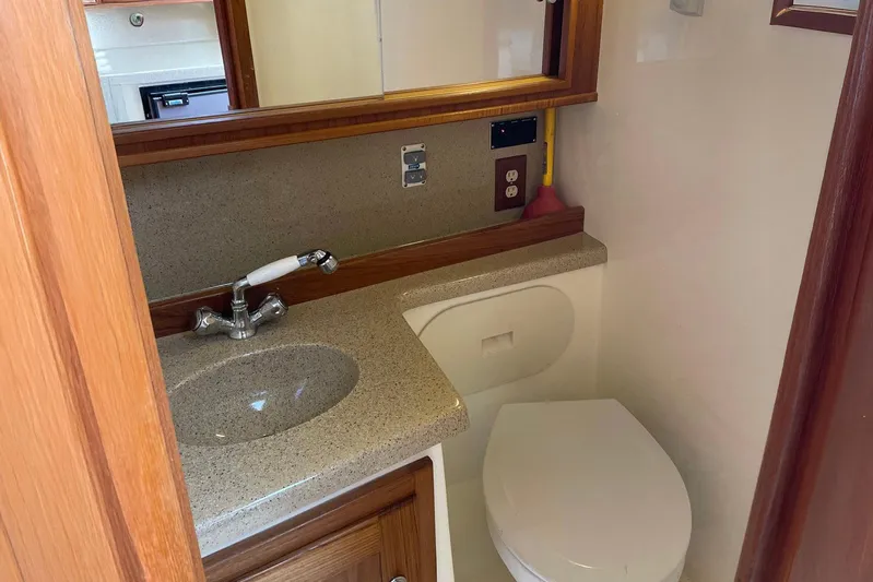 Low Bid Yacht Photos Pics Compact bathroom in 2007 Albemarle 280 Express Fisherman boat with sink and toilet.
