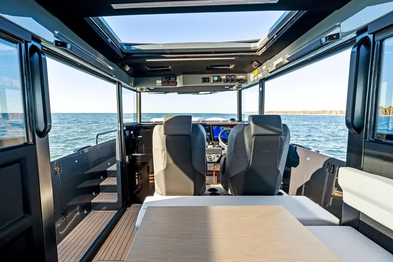  Yacht Photos Pics Interior view of 2025 XO Boats EXPLR 44, showcasing helm and seating area on open water.