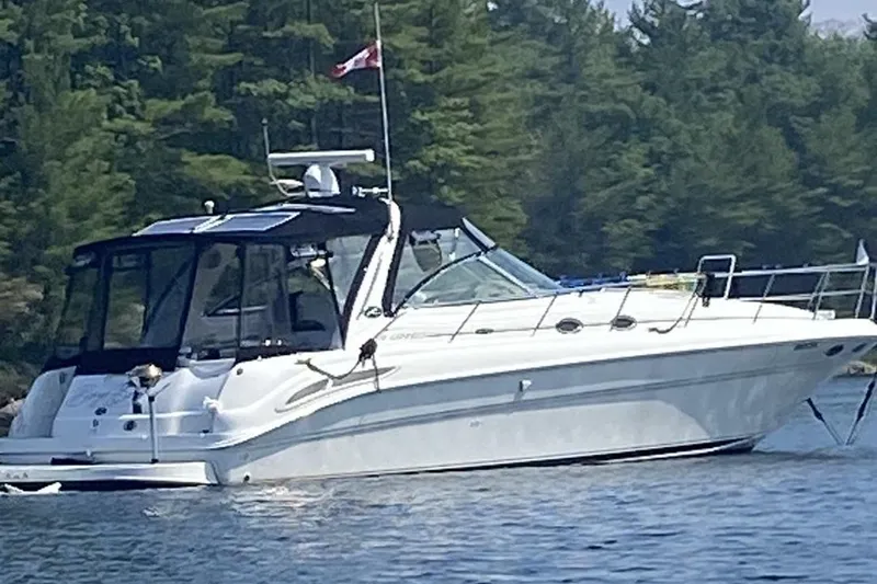  Yacht Photos Pics 2001 Sea Ray 410 Express Cruiser anchored on a serene lake with forest backdrop.
