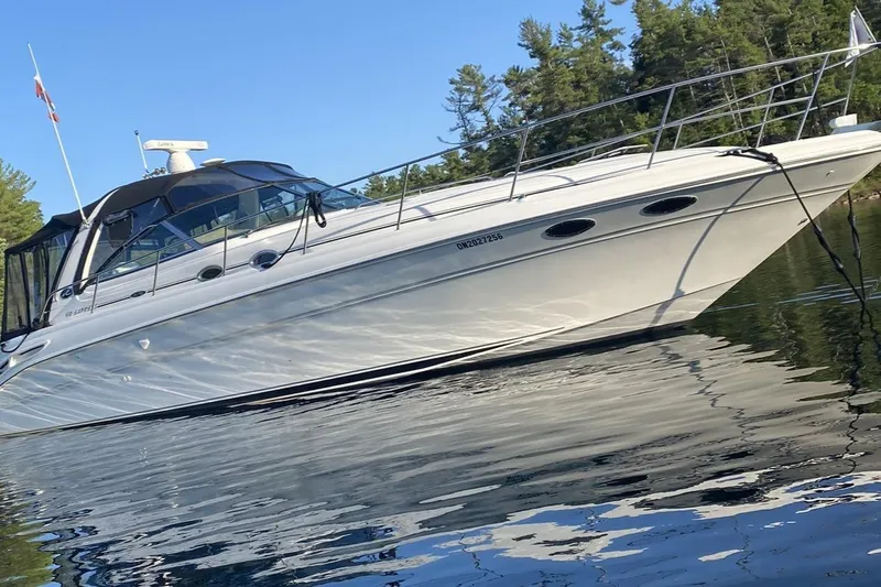  Yacht Photos Pics 2001 Sea Ray 410 Express Cruiser on calm water with forested background.