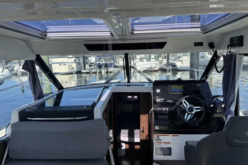 Zoom Away Yacht Photos Pics Interior view of 2020 Jeanneau NC 1095 boat cockpit with steering wheel and navigation controls.
