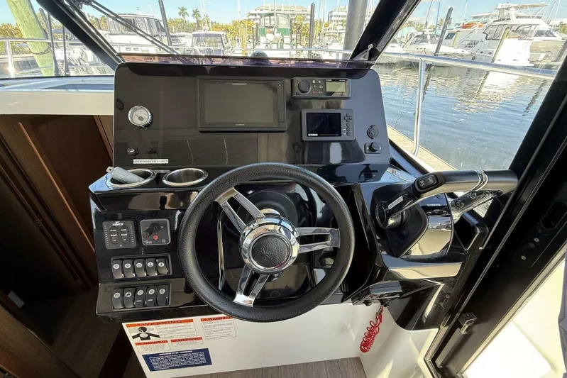 Zoom Away Yacht Photos Pics 2020 Jeanneau NC 1095 helm with steering wheel and control panel at marina.