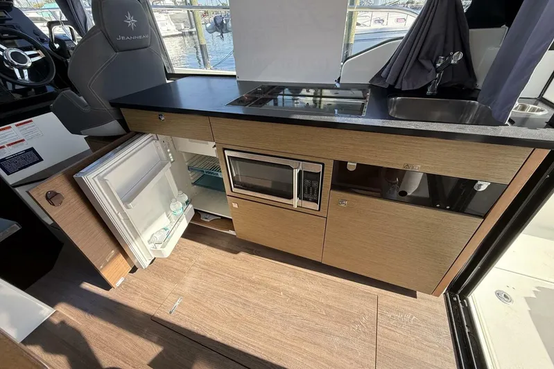 Zoom Away Yacht Photos Pics 2020 Jeanneau NC 1095 boat interior kitchen with fridge, microwave, and sink.
