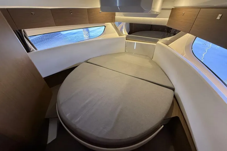 Zoom Away Yacht Photos Pics Interior cabin of 2020 Jeanneau NC 1095 with circular bed and wooden storage.