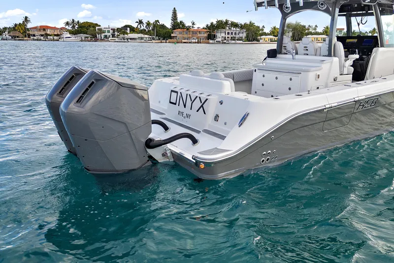 Onyx Yacht Photos Pics 2023 HCB 39 Speciale boat with dual engines on clear water near shoreline.
