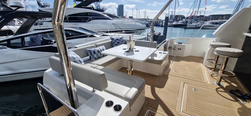  Yacht Photos Pics 2024 Aquila 44 Yacht with elegant seating and table on deck, docked at marina.