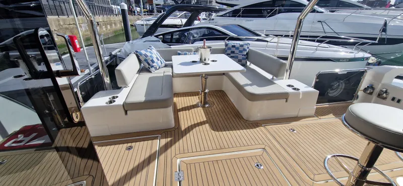  Yacht Photos Pics 2024 Aquila 44 Yacht deck with seating and table, featuring modern design and wood flooring.