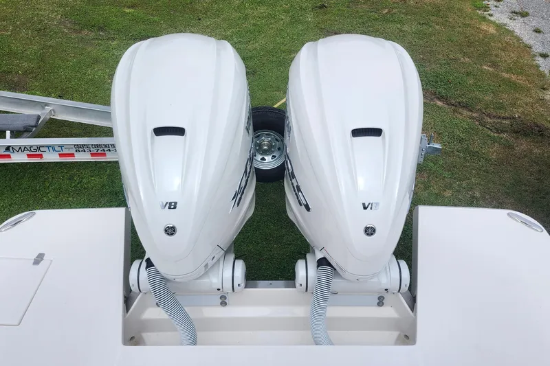  Yacht Photos Pics Twin V8 outboard engines on a 2026 Regal 36 XO boat, parked on grass.