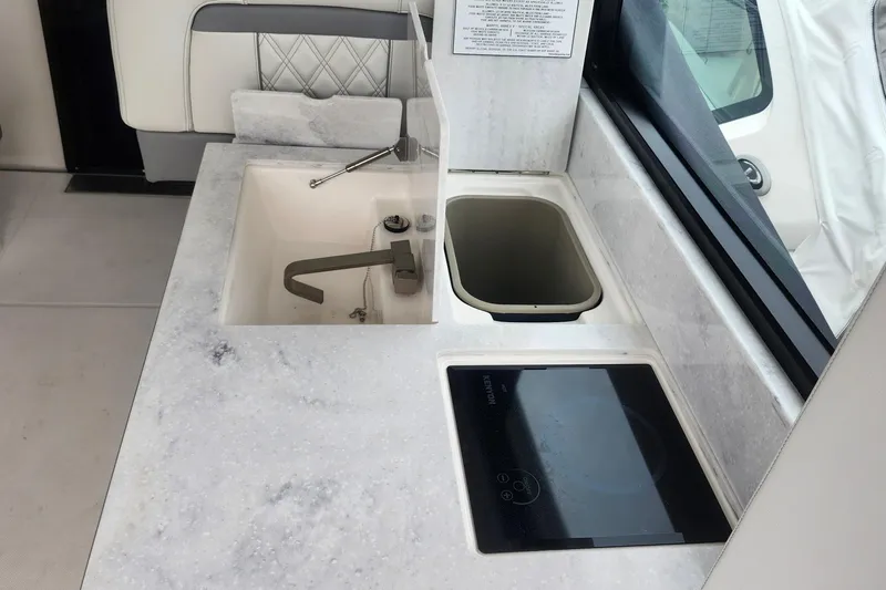  Yacht Photos Pics Modern kitchen area on a 2026 Regal 36 XO yacht with sink and induction cooktop.