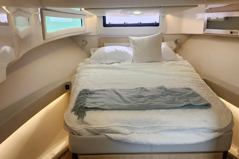  Yacht Photos Pics Luxurious cabin interior of 2026 Regal 36 XO yacht with cozy bed and elegant decor.