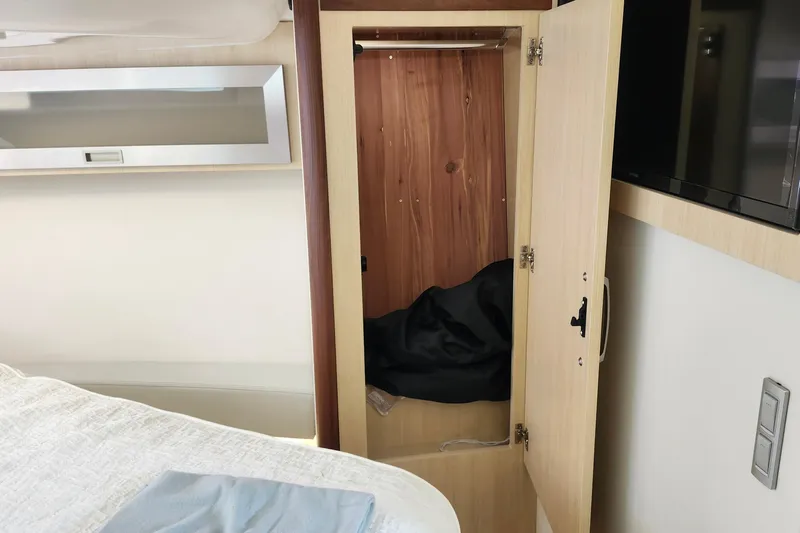  Yacht Photos Pics Interior of 2026 Regal 36 XO yacht showing open wooden closet and bed.