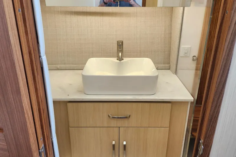  Yacht Photos Pics Modern bathroom sink in 2026 Regal 36 XO yacht, featuring sleek design and wooden cabinetry.