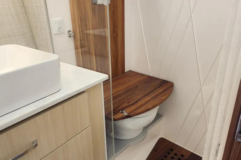  Yacht Photos Pics Luxury bathroom in 2026 Regal 36 XO yacht with wooden accents and modern fixtures.