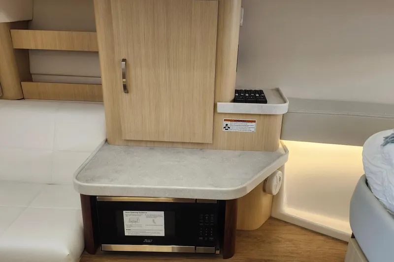  Yacht Photos Pics Interior of 2026 Regal 36 XO yacht with microwave and wooden cabinetry.